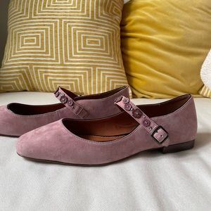 Pink suede ballerinas with flower pattern strap.